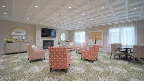 Lounge with patterned armchairs, a fireplace and round mirrors