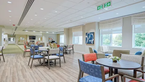 Room with round tables, coloured chairs and large windows