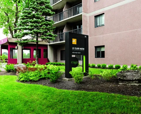 Freestanding residence sign beside a brick facade and landscaped flower beds