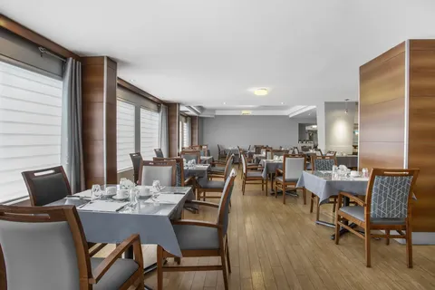 Dining room with set tables, wooden chairs and large windows