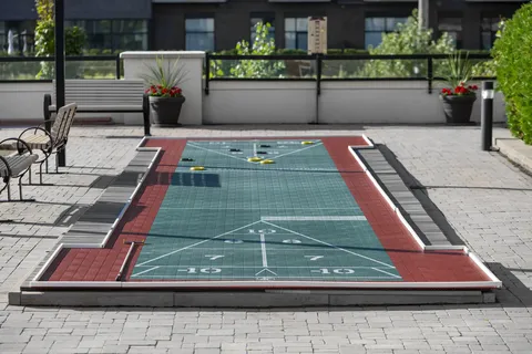 Outdoor shuffleboard court beside planters and patio furniture
