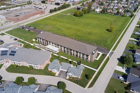 Aerial view of the residence building beside lawns and nearby homes