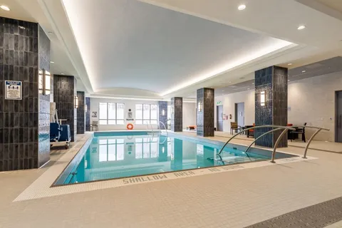 Indoor swimming pool with handrails and windows