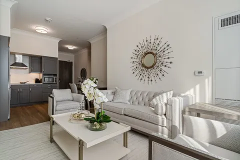 Sitting area with a grey sofa, armchairs and a kitchenette