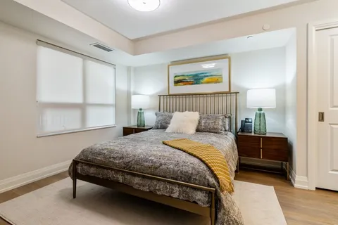 Bedroom with a patterned bedspread and yellow throw