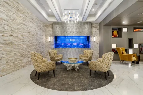 Armchairs around a glass coffee table in front of an aquarium