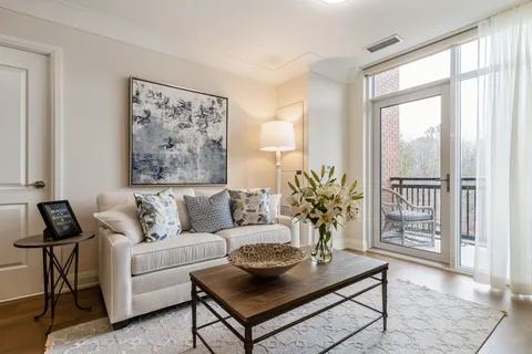 Sitting area with a sofa and coffee table beside a balcony door