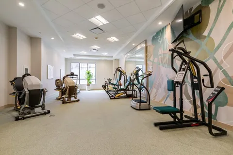 Fitness room with exercise machines and a blank television