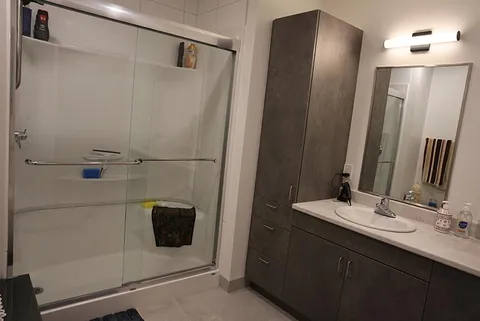 Bathroom with a glass shower enclosure, vanity and mirror