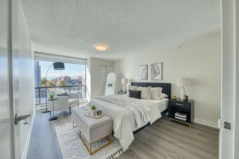 Studio suite with a bed, seating and large windows.