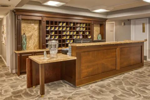 Reception counter with wood panelling, mail cubbies and decorative shelving.