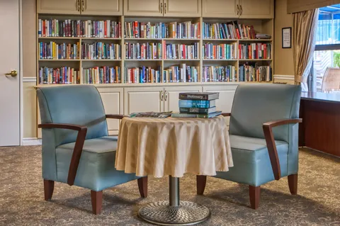 Library with bookcases, armchairs and a round table.