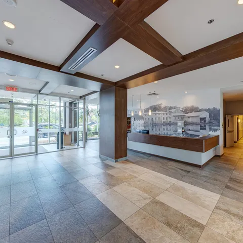 Reception counter and glass entrance doors beneath wooden ceiling beams