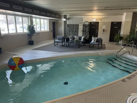 Indoor swimming pool with a beach ball and a seating area