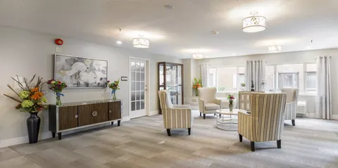 Lounge with striped armchairs, round tables and large windows