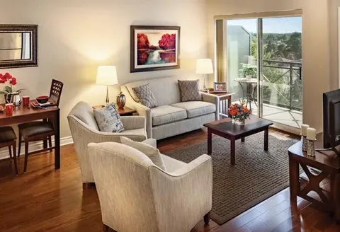 Suite living area with a sofa, armchairs and dining table.