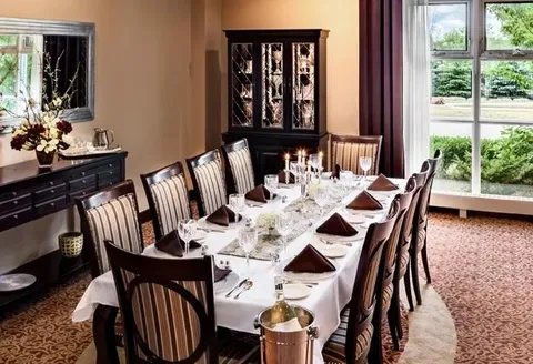 Private dining room with a long table and china cabinets.