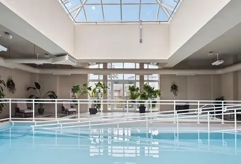 Indoor swimming pool beneath a skylight.