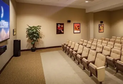 Theatre with a projection screen and rows of seats.