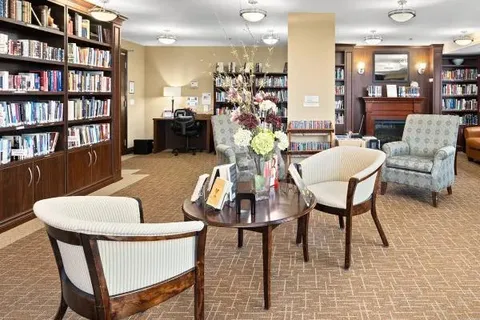Library with bookshelves, armchairs and a round table.