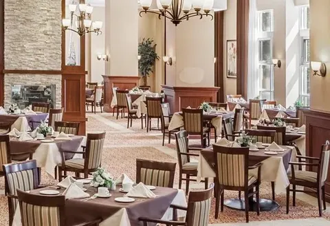 Dining room with set tables, wood trim and large windows.
