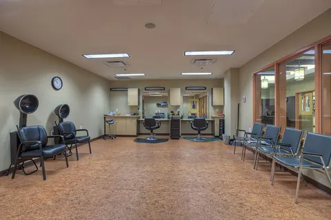 Hair salon with styling chairs and wash basins.