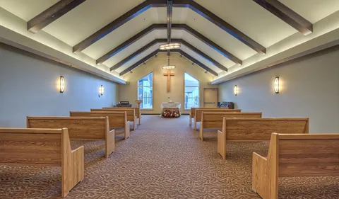 Chapel with wooden pews and a vaulted ceiling.