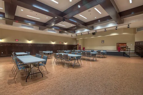 Event room with tables, chairs and a stage.