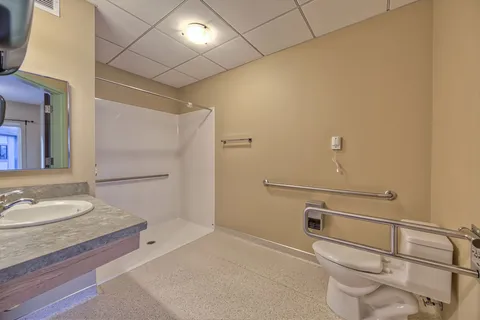 Accessible suite bathroom with a shower and grab rails.