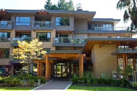 Building façade with balconies and a covered glass entrance