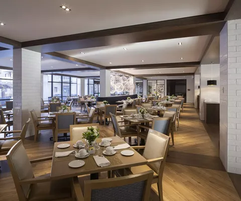 Dining room with set tables, wooden chairs and large windows