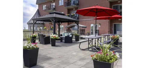 Patio with a gazebo, outdoor chairs, flower planters and red umbrellas