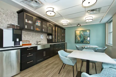 Cafe seating beside a counter and dark kitchen cabinets