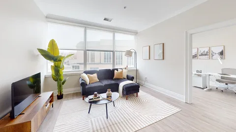 Suite living room with a sofa and television beside large windows