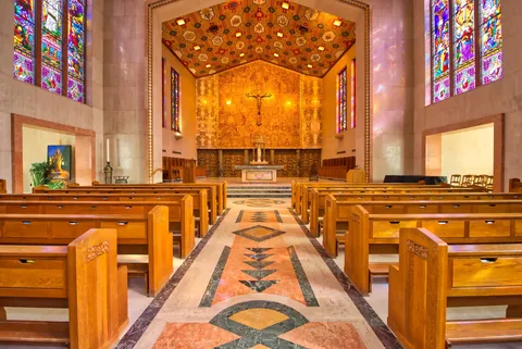 Chapel with wooden pews, stained-glass windows and an altar