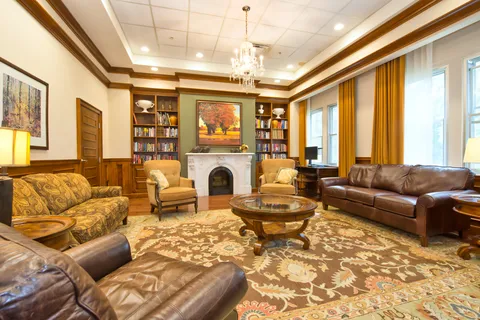 Library lounge with bookshelves, sofas and a fireplace