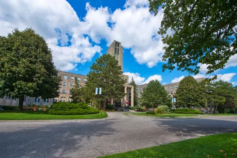 Residence exterior and tower beside a landscaped entrance drive