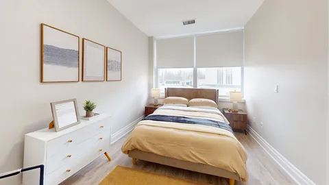 Bedroom with a double bed beside large windows