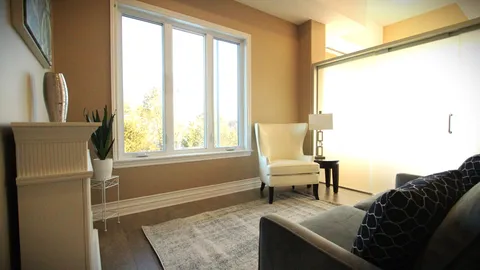 Suite sitting room with a sofa, armchair, fireplace and large windows.