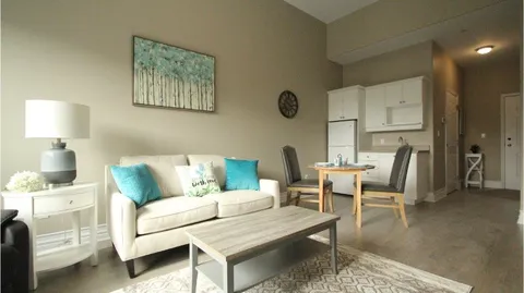 Suite living and dining area with a sofa, table and kitchenette.