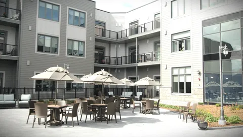 Courtyard patio with tables and umbrellas between residence wings.