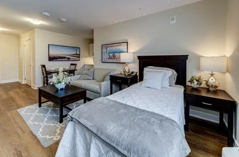 Suite with a single bed, sofa, coffee table and dining area