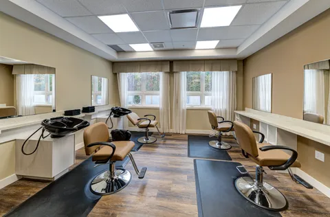 Hair salon with styling chairs, mirrors, wash basins and large windows