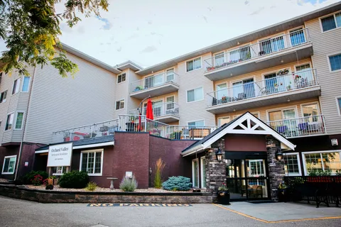 Multi-storey residence with balconies, landscaped beds and a covered entrance
