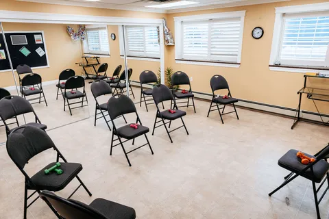Exercise room with chairs, small weights and large windows