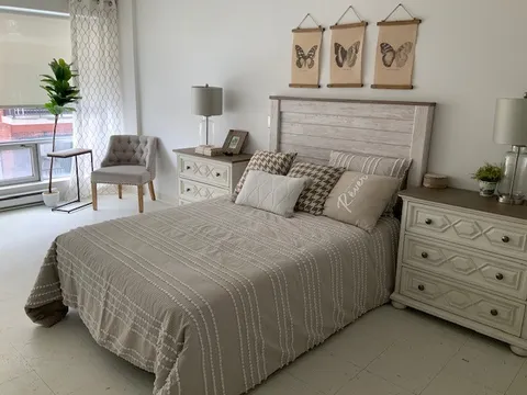 Bedroom with a double bed, bedside cabinets, lamps and butterfly wall hangings