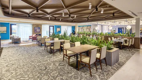 Dining tables and chairs beneath a timber ceiling.