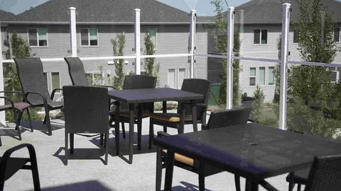 Patio with dark tables and chairs overlooking a residential building