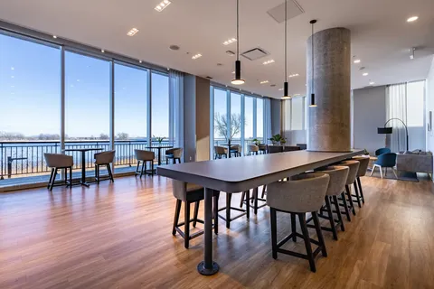 Room with a long table, chairs and windows overlooking water