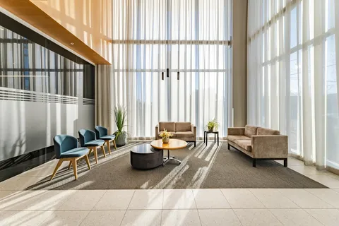 Seating area beneath tall windows and a high ceiling
